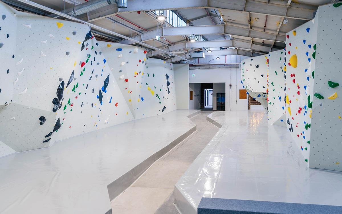 Große Boulderhalle mit Überhängen und Routen in verschiedenen Farben im Stuntwerk Krefeld – perfekt zum Technik- und Krafttraining.
