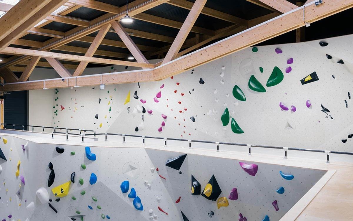 Empore mit einer Boulderwand, mit vielen bunten Griffen und Routen.