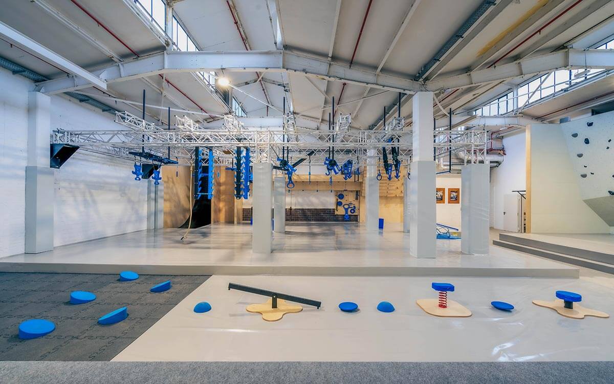 Ninja-Parcours im Stuntwerk Krefeld mit blauen Hindernissen und verschiedenen Elementen für Geschicklichkeit und Kraft.