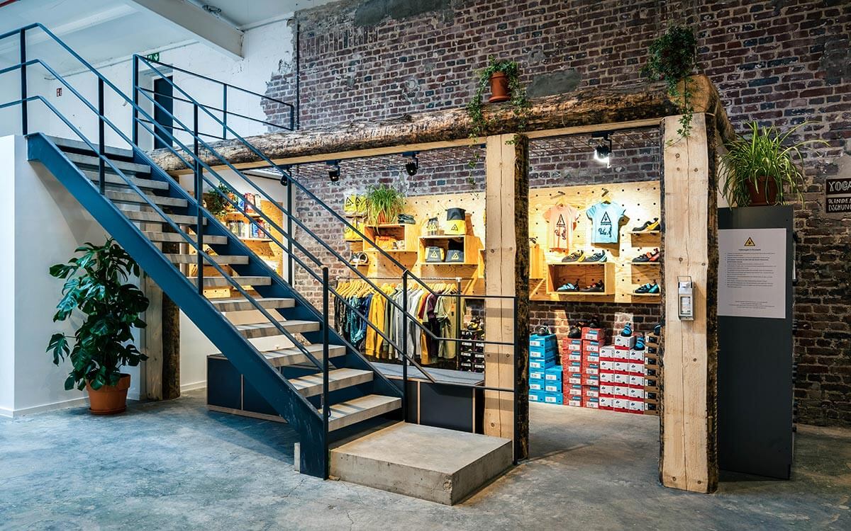 Stuntwerk Shop in Krefeld mit Kletterequipment, Schuhen und Kleidung auf Holzmodulen.