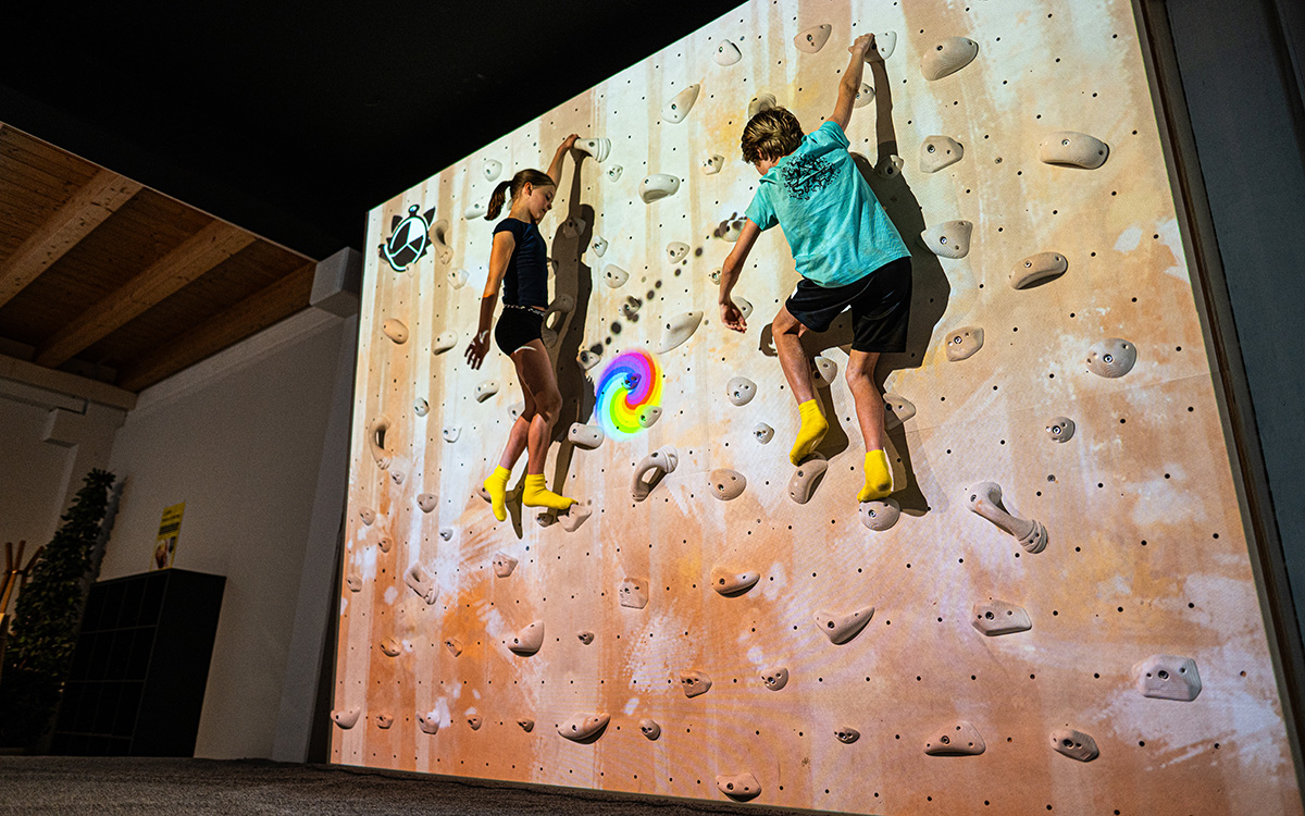 Kinder klettern an der interaktiven ValoClimb-Wand im Stuntwerk Trostberg mit digitalen Spielen und Projektionen